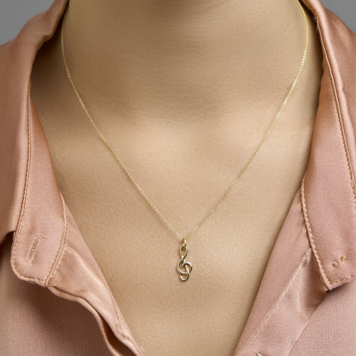 Basis | Geelgouden bedel met een G-sleutel